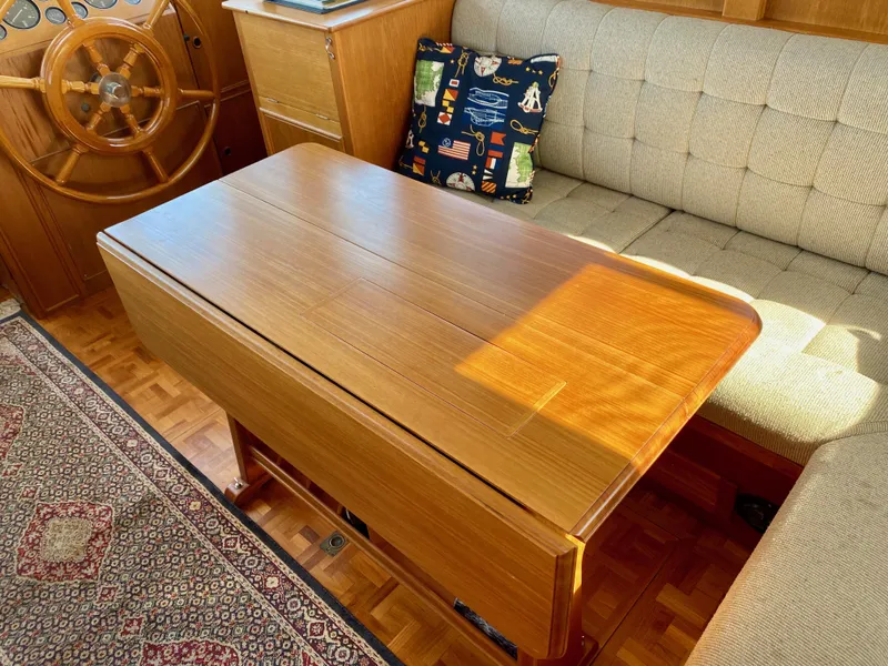 Slide: The Image of Interior of a 1997 Grand Banks Classic yacht with wooden table and cushioned seating. - 13
