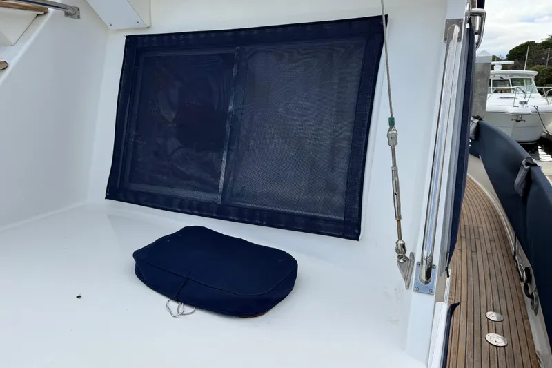 Slide: The Image of 1997 Grand Banks Classic boat deck with blue cushion and window cover. - 60