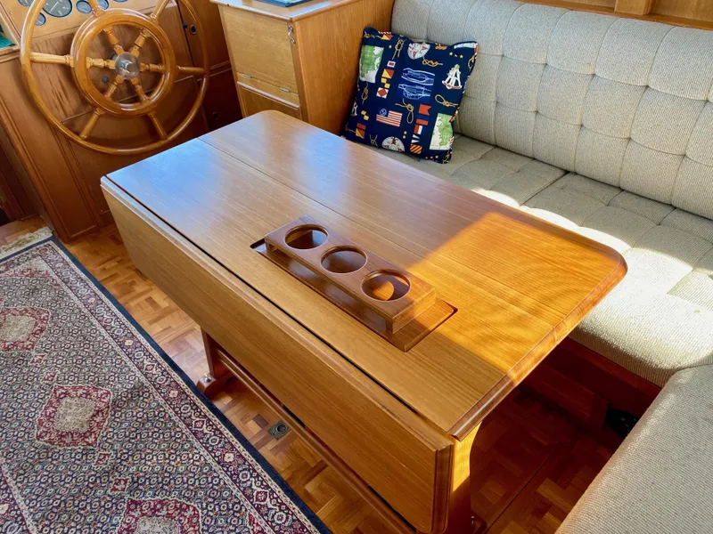 Slide: The Image of Cozy 1997 Grand Banks Classic interior with wooden table, nautical decor, and plush seating. - 14