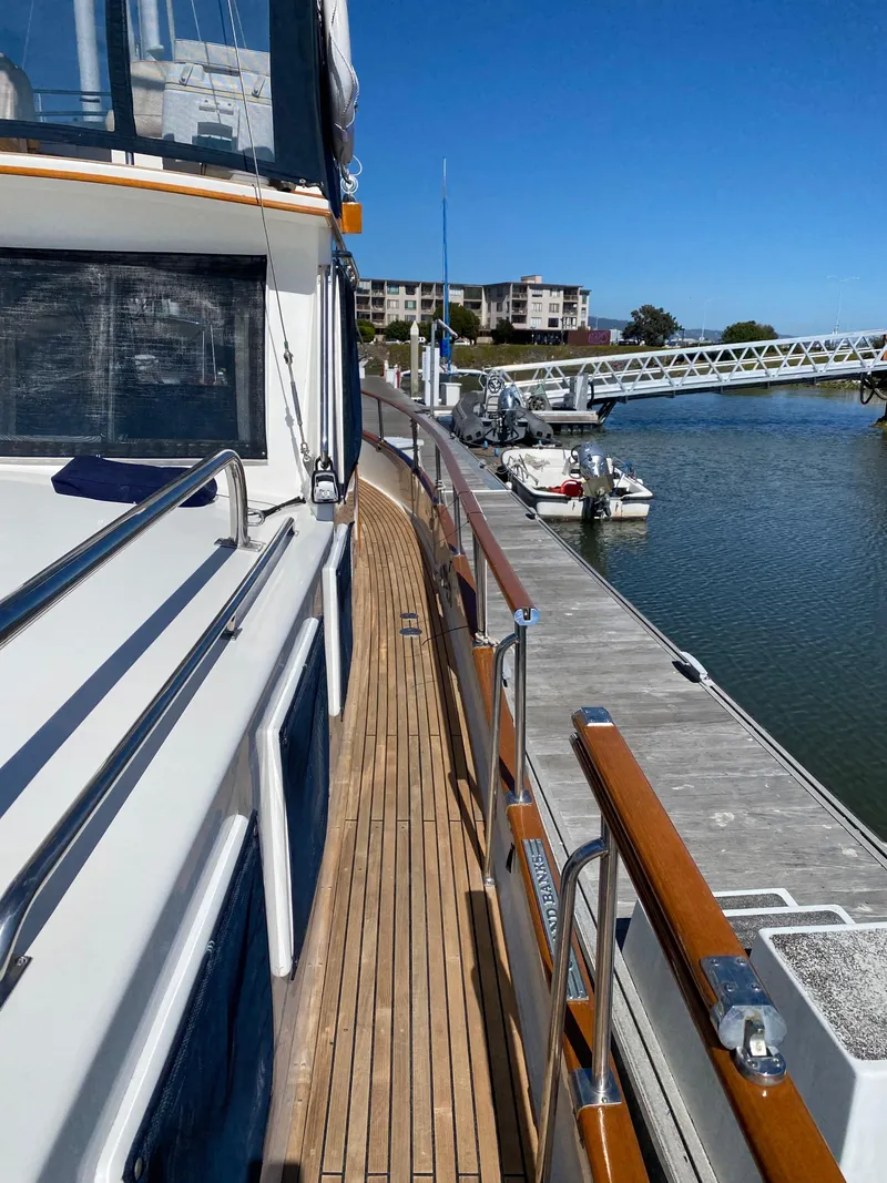 Slide: The Image of 1997 Grand Banks Classic yacht docked at marina, showcasing wooden deck and sleek design. - 41