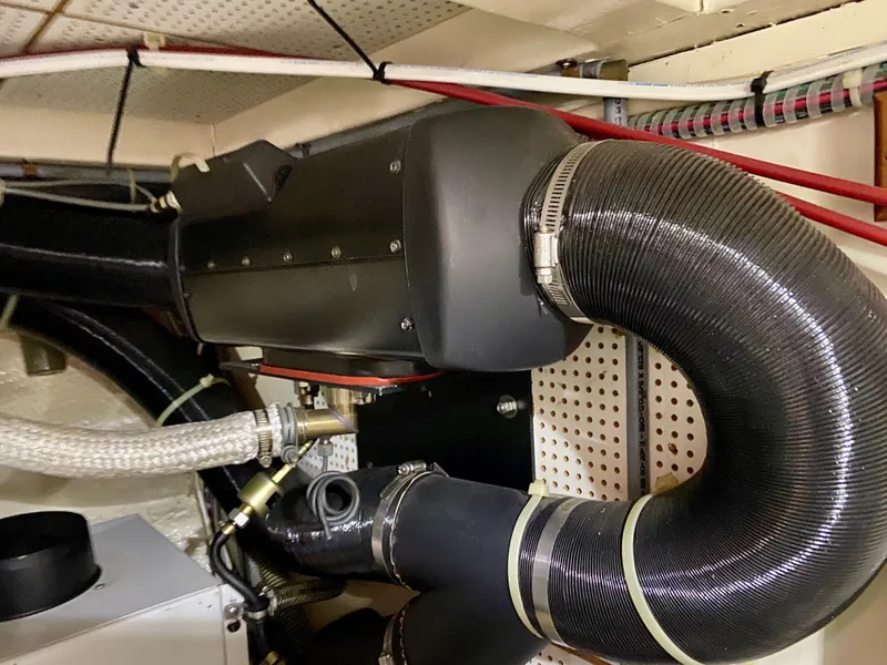 Slide: The Image of Engine room of a 1997 Grand Banks Classic boat with visible hoses and components. - 49
