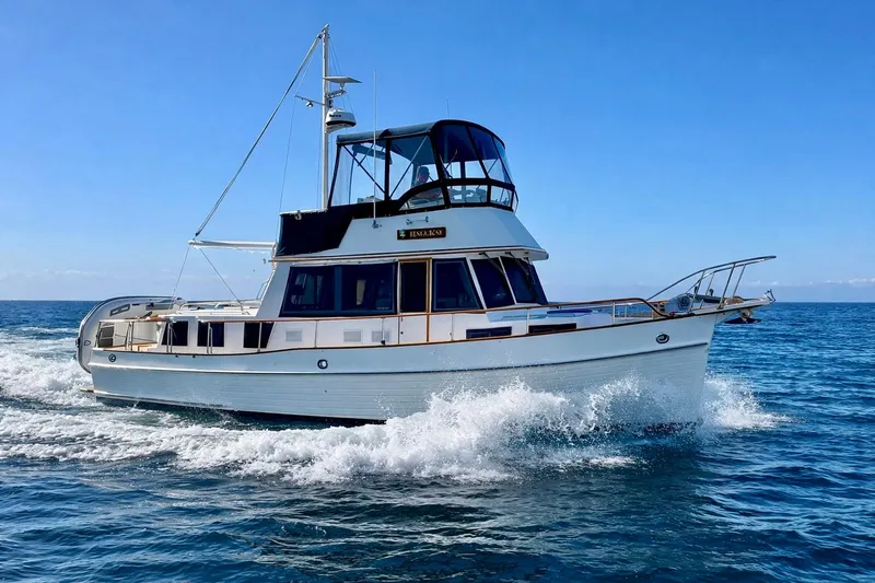 The Image of 1997 Grand Banks Classic yacht cruising on open sea under clear blue sky. - 0