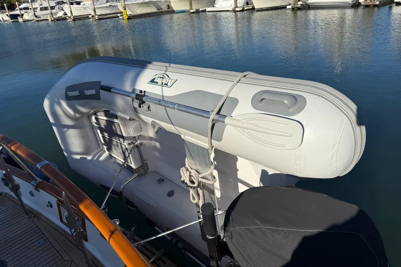 Slide: The Image of Inflatable dinghy secured on a 1997 Grand Banks Classic yacht at a marina. - 61