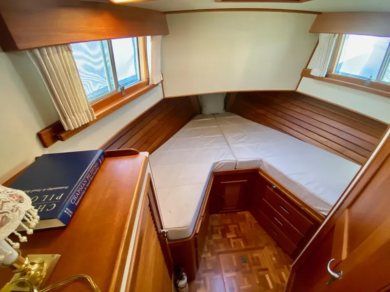 Slide: The Image of 1997 Grand Banks Classic cabin with cozy bed, wooden interior, and nautical decor. - 34