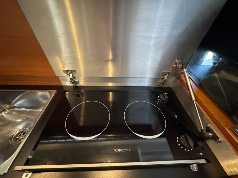 Slide: The Image of The 2017 Jeanneau NC 11 features a modern two-burner cooktop in its galley. - 23