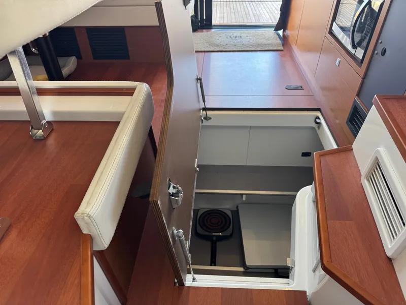 Slide: The Image of Interior of the 2017 Jeanneau NC 11 with an open floor hatch revealing storage below. - 28