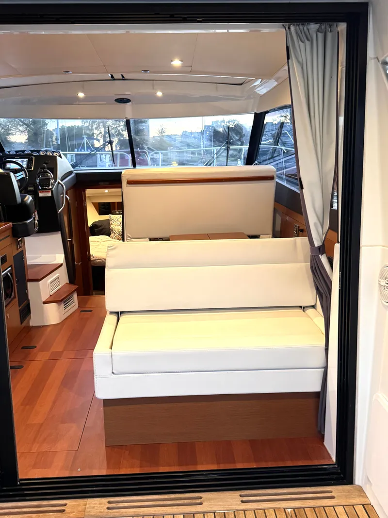Slide: The Image of Interior of a 2017 Jeanneau NC 11 with wooden flooring and white upholstery. - 20