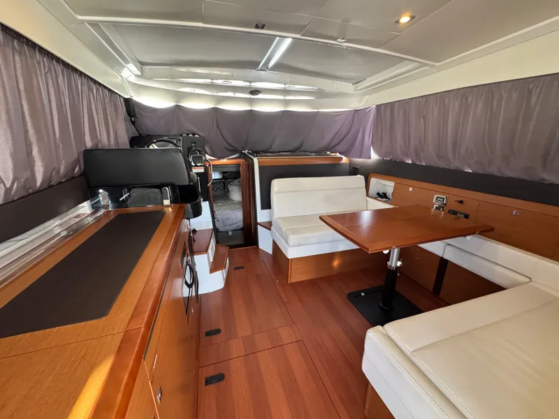 Slide: The Image of Interior of a 2017 Jeanneau NC 11 with wood flooring, white sofa, and dining table. - 27