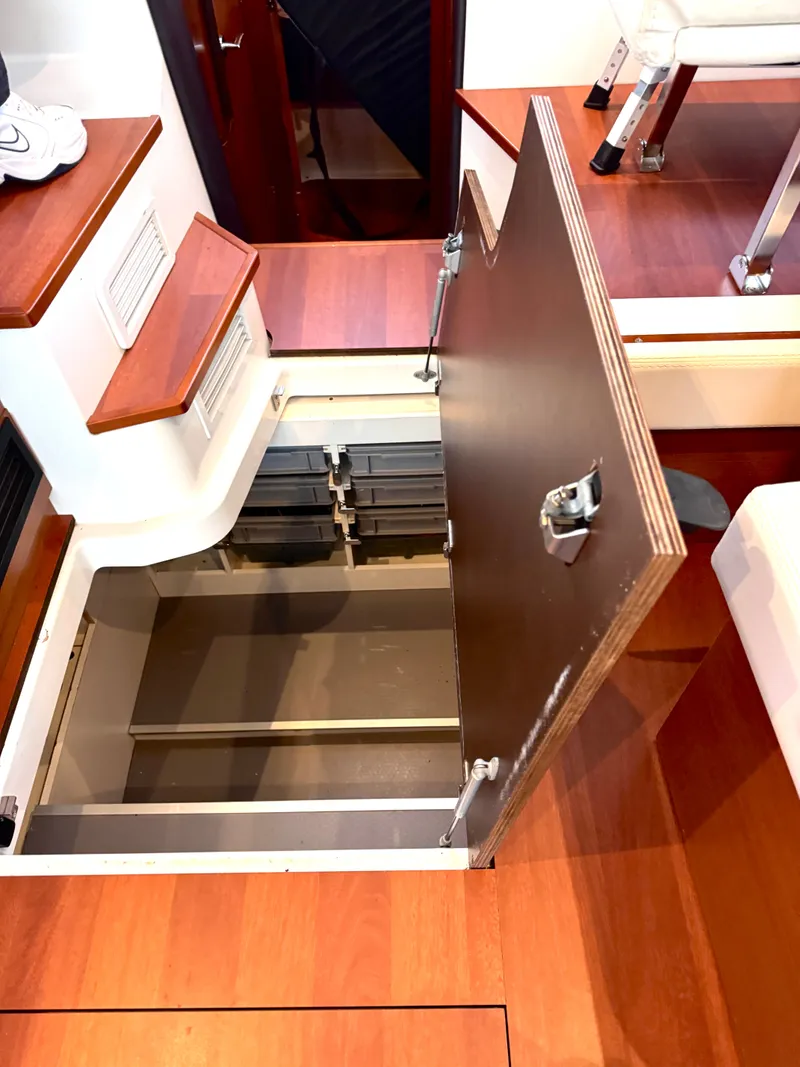 Slide: The Image of The interior of the 2017 Jeanneau NC 11 features an open floor hatch with storage underneath. - 34