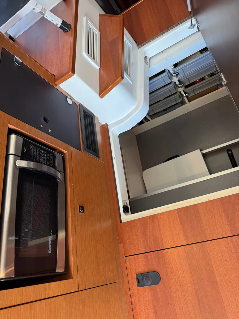 Slide: The Image of Interior of the 2017 Jeanneau NC 11 with microwave and wood paneling. - 30