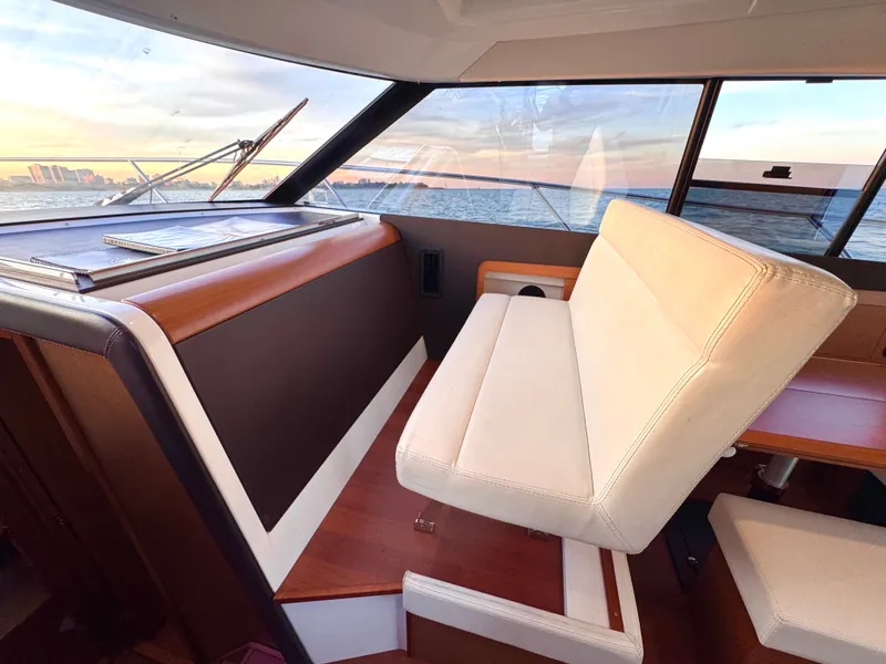 Slide: The Image of Interior of a 2017 Jeanneau NC 11 with white seating and wood accents. - 22