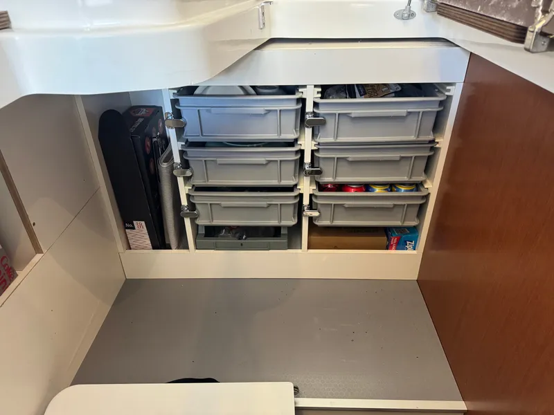 Slide: The Image of A storage area with multiple drawers filled with various items inside a boat. - 36