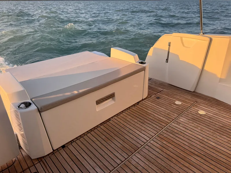 Slide: The Image of The image shows the stern of a 2017 Jeanneau NC 11 with a wooden deck and bench. - 13