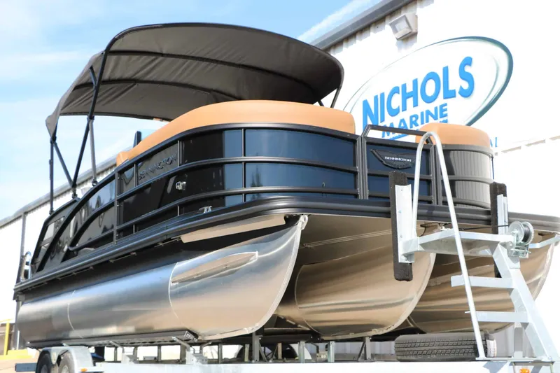 Slide: The Image of A sleek 2026 Bennington 22 MSB Tri Toon on a trailer, featuring black railings and a sunshade. - 8