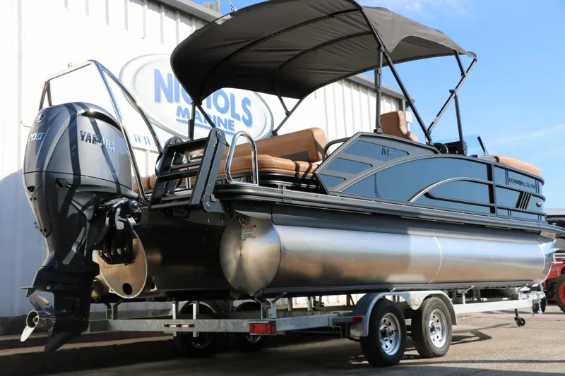 Slide: The Image of 2026 Bennington 22 MSB Tri Toon with Yamaha outboard motor, on a trailer in front of a building. - 17