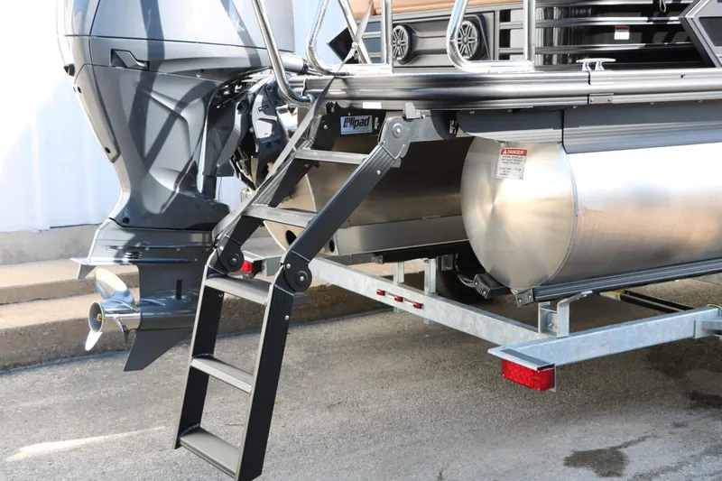 Slide: The Image of The image shows the rear of a Bennington 22 MSB Tri Toon with an outboard motor and ladder. - 28