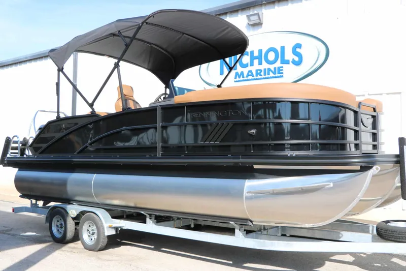 Slide: The Image of 2026 Bennington 22 MSB Tri Toon on a trailer, featuring a black canopy and brown seating. - 5