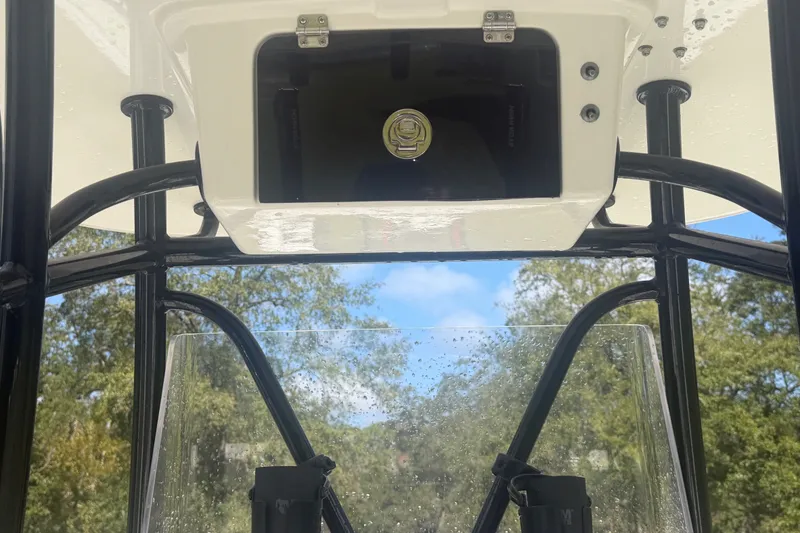 Slide: The Image of 2022 Pair Customs 21 Center Console DV boat interior with storage compartment and clear windshield. - 3
