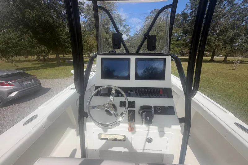 Slide: The Image of 2022 Pair Customs 21 Center Console DV boat interior with dual screens and steering wheel. - 2