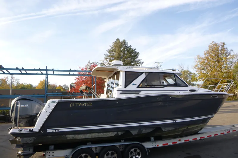 The Image of 2025 Cutwater C-288 Coupe boat on trailer, parked outdoors under clear sky. - 0