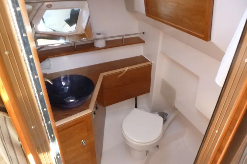 Slide: The Image of 2025 Cutwater C-288 Coupe bathroom with modern sink, toilet, and wooden cabinetry. - 17