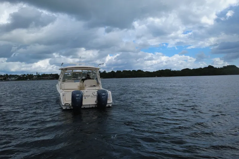 Slide: The Image of 2021 Grady-White Freedom 335 boat on a calm lake under cloudy skies. - 6