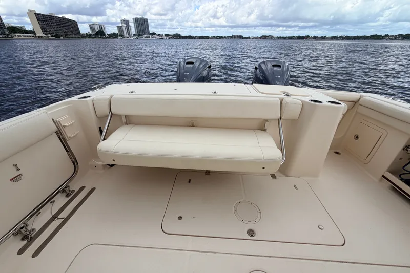 Slide: The Image of 2021 Grady-White Freedom 335 boat interior with seating and twin engines on a calm water backdrop. - 39