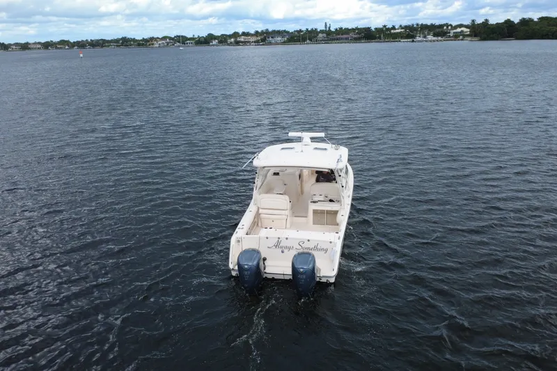Slide: The Image of 2021 Grady-White Freedom 335 boat cruising on a calm lake under a cloudy sky. - 9