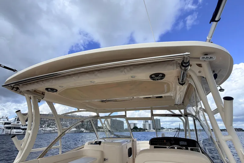 Slide: The Image of 2021 Grady-White Freedom 335 boat interior with canopy, docked near cityscape under cloudy sky. - 73
