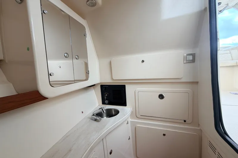 Slide: The Image of 2021 Grady-White Freedom 335 boat interior with sink, cabinets, and mirror. - 22