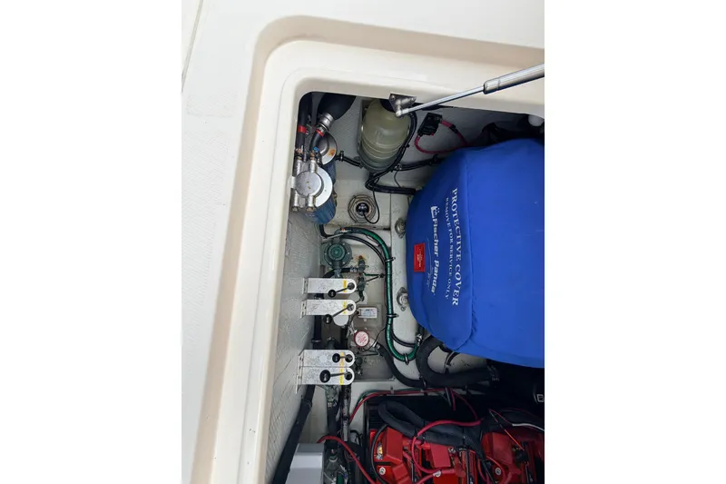 Slide: The Image of Engine compartment of 2021 Grady-White Freedom 335 boat, showing mechanical components and protective cover. - 63