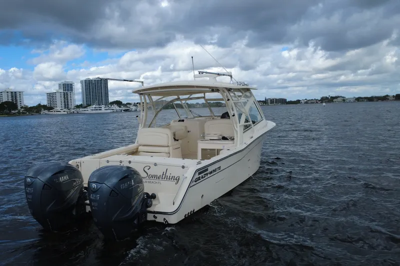 Slide: The Image of 2021 Grady-White Freedom 335 boat on water with twin Yamaha engines, cityscape background. - 7