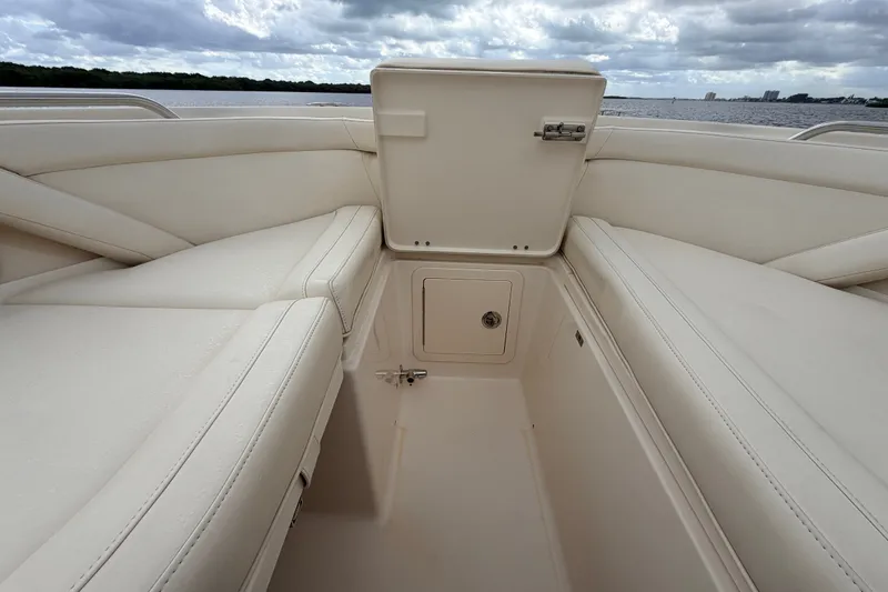 Slide: The Image of 2021 Grady-White Freedom 335 boat interior with open storage compartment, under cloudy sky. - 27