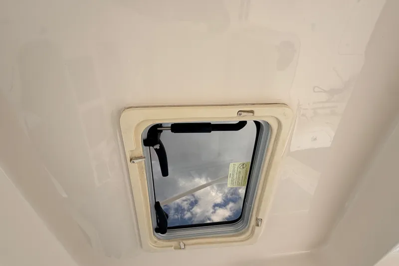 Slide: The Image of Hatch window on 2021 Grady-White Freedom 335 boat, showing sky reflection. - 75