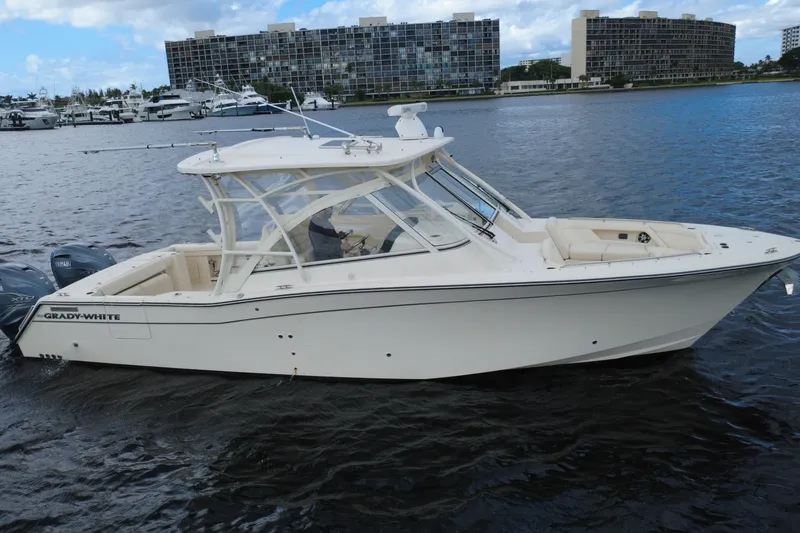 Slide: The Image of 2021 Grady-White Freedom 335 boat on water, with modern buildings in background. - 4
