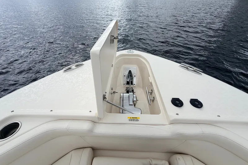 Slide: The Image of 2021 Grady-White Freedom 335 boat anchor compartment open on calm water. - 26
