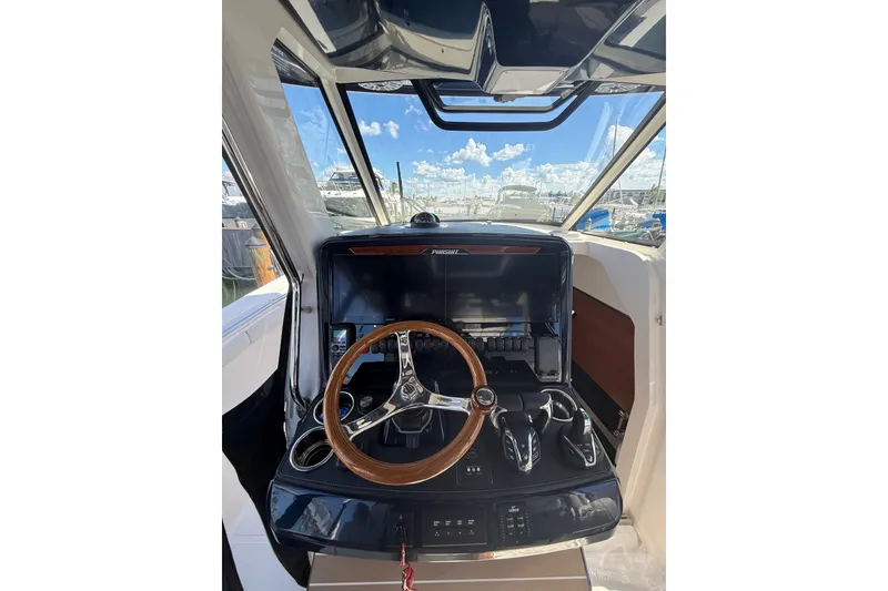 Slide: The Image of Interior view of 2025 Pursuit S 328 Sport boat cockpit with steering wheel and controls. - 3