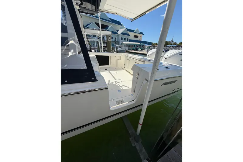 Slide: The Image of 2025 Pursuit S 328 Sport boat docked at marina, showcasing spacious deck and sleek design. - 11