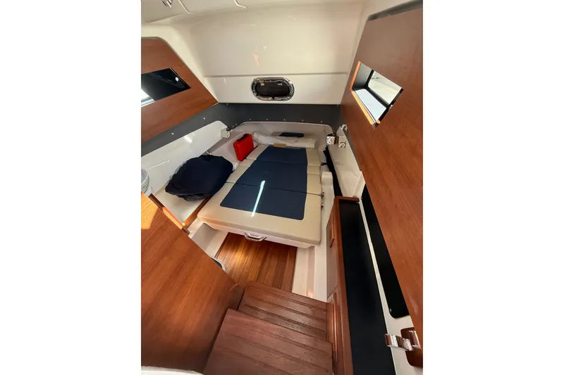 Slide: The Image of 2025 Pursuit S 328 Sport cabin interior with wooden accents and cozy seating. - 14