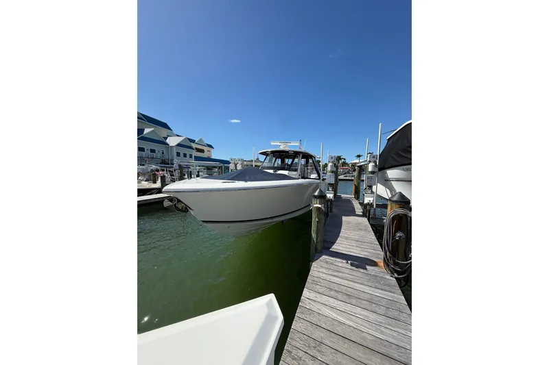 Slide: The Image of 2025 Pursuit S 328 Sport boat docked at marina under clear blue sky. - 2