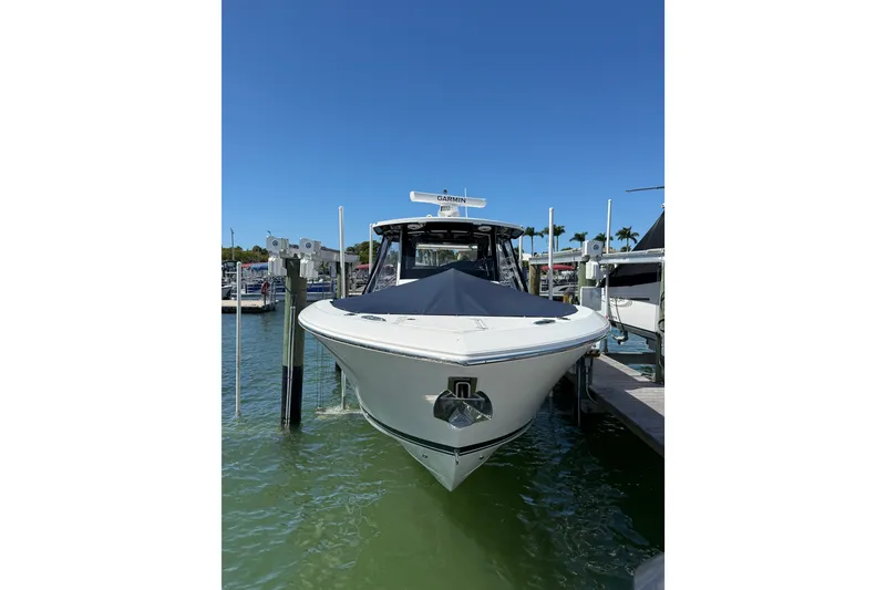 Slide: The Image of 2025 Pursuit S 328 Sport boat docked in marina under clear blue sky. - 1
