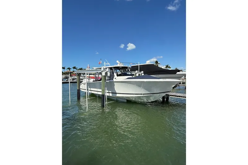 The Image of 2025 Pursuit S 328 Sport boat docked on a sunny day with clear blue skies. - 0