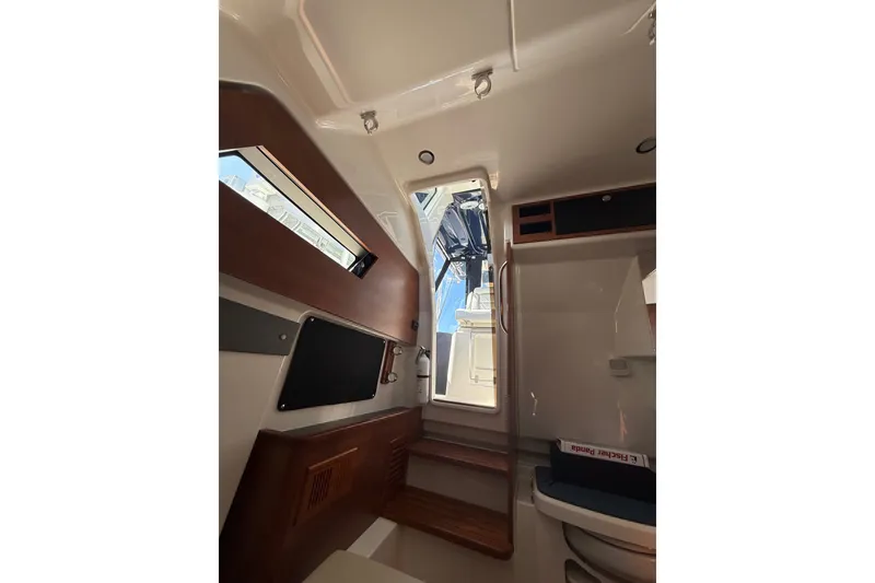 Slide: The Image of Interior view of 2025 Pursuit S 328 Sport boat cabin with wooden accents. - 16