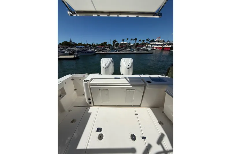 Slide: The Image of 2025 Pursuit S 328 Sport boat deck with dual engines, docked at marina. - 6
