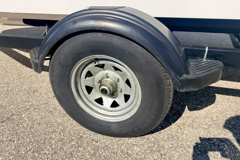 Slide: The Image of Trailer wheel of a 2017 Chaparral 19 Sport H2O on asphalt surface. - 76
