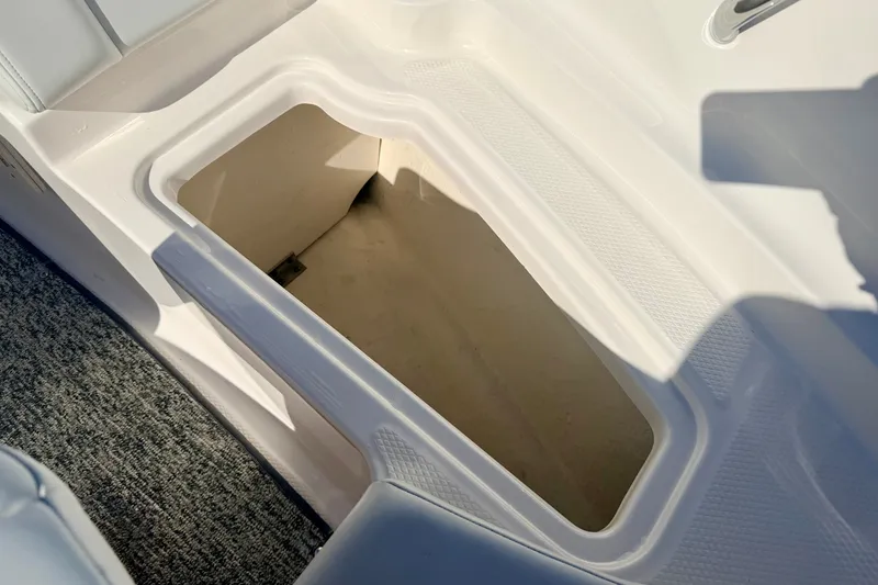 Slide: The Image of Storage compartment in 2017 Chaparral 19 Sport H2O boat, featuring white interior and carpeted flooring. - 63