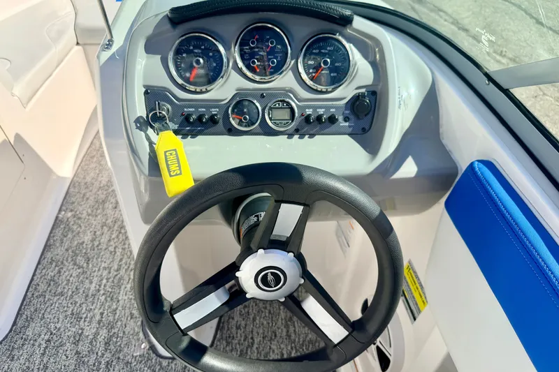 Slide: The Image of Steering wheel and dashboard of 2017 Chaparral 19 Sport H2O boat, featuring gauges and controls. - 45