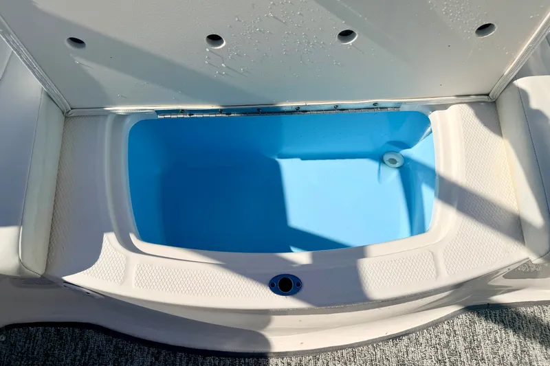 Slide: The Image of 2017 Chaparral 19 Sport H2O boat storage compartment with blue interior. - 43