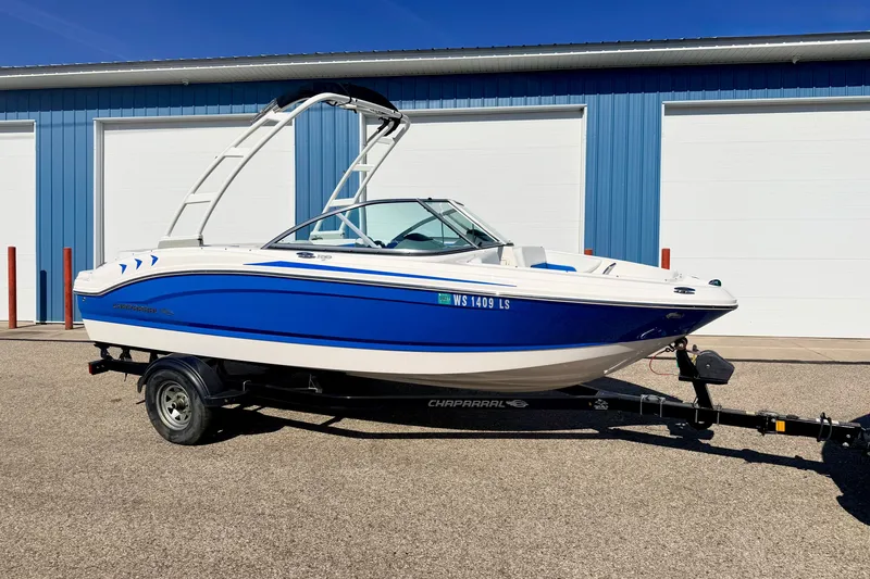 The Image of 2017 Chaparral 19 Sport H2O boat in blue and white, parked on a trailer. - 0