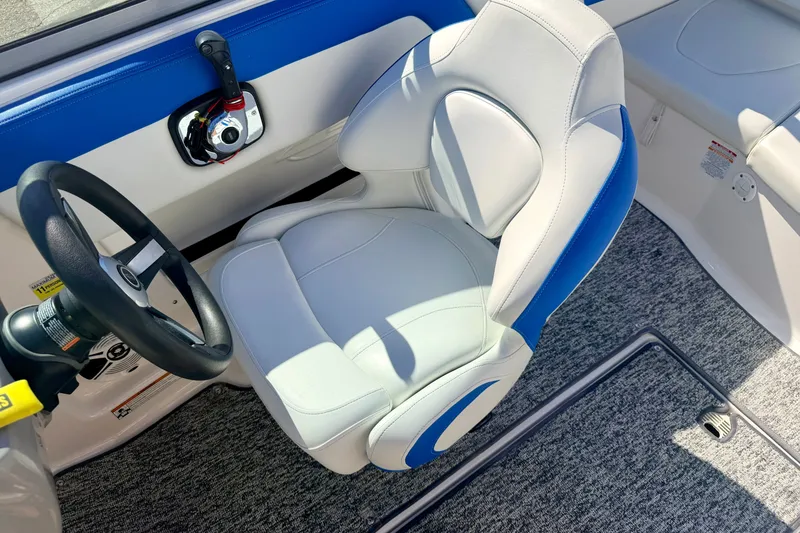 Slide: The Image of 2017 Chaparral 19 Sport H2O boat interior with steering wheel and blue-accented seat. - 50